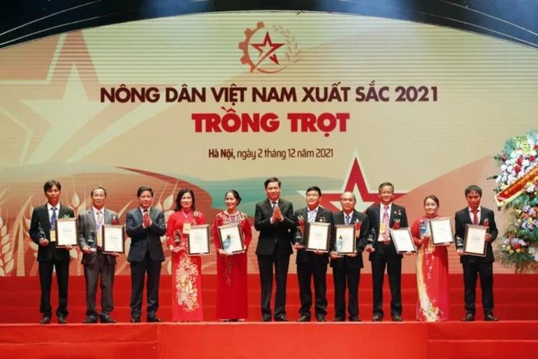 Đồng chí Lê Quốc Doanh và đồng chí Nguyễn Long Hải trao danh hiệu Nông dân Việt Nam xuất sắc cho nhóm nông dân trong lĩnh vực trồng trọt. (Ảnh: danviet.vn) Lễ tôn vinh và trao danh hiệu cho 63 “Nông dân Việt Nam xuất sắc 2021” -0