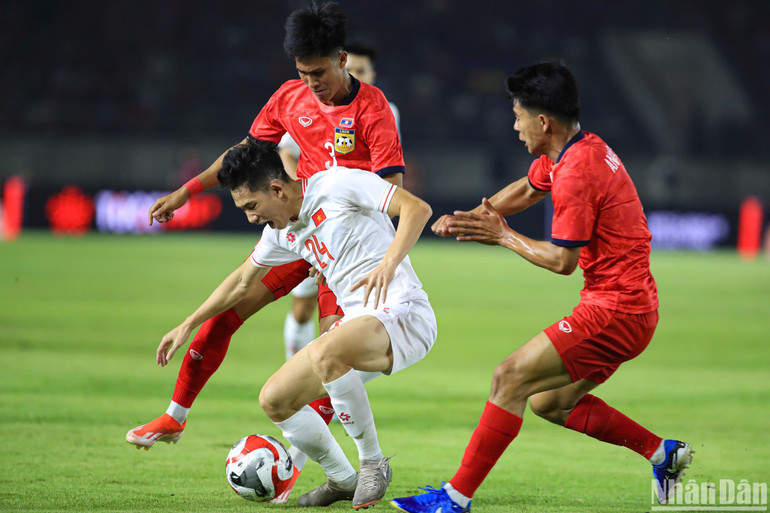 Các cầu thủ Lào ngăn chặn Hai Long tấn công. (Ảnh: HÀ AN)