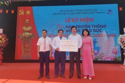 Đại diện Báo Nhân Dân trao biểu trưng 20 suất học bổng đến lãnh đạo Trường trung học phổ thông Tiền Phong. 