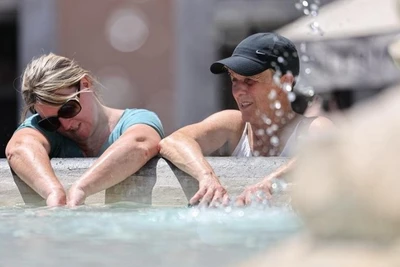 Du khách giải nhiệt tại đài phun nước ở Roma, Italia. (Ảnh: TÂN HOA XÃ) 