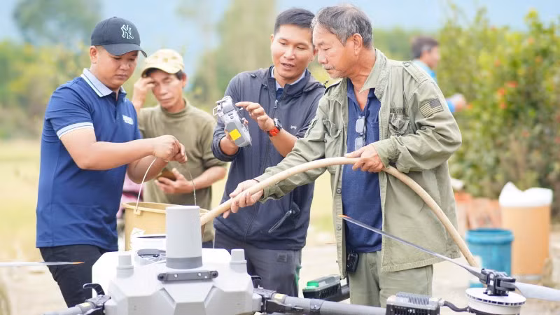 Các thành viên nhóm Drone Phản ứng nhanh thuộc Ứng cứu 3 miền bơm nước vào bình để pha hoá chất khử khuẩn.
