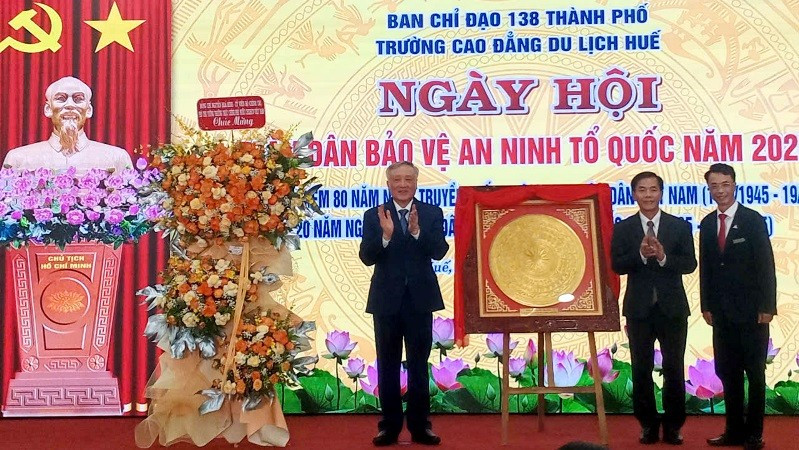 Phó Thủ tướng Thường trực Nguyễn Hòa Bình và Chủ tịch Ủy ban nhân dân thành phố Huế Nguyễn Văn Phương tặng hoa và quà (hiện vật) của Trung ương cho Trường cao đẳng Du lịch Huế. a.jpg