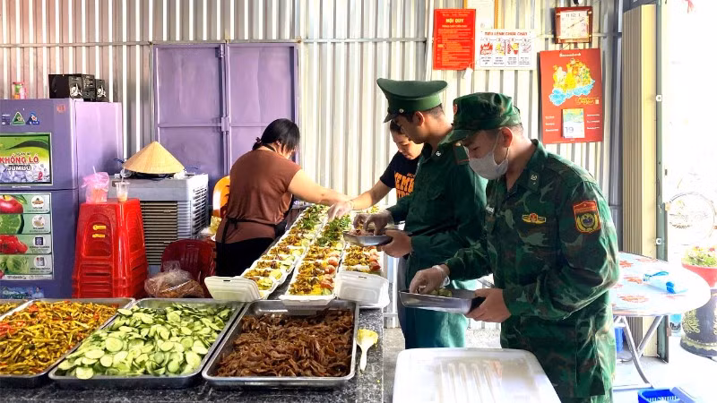 Cán bộ, chiến sĩ Đồn Biên phòng Xuân Đài cùng các tình nguyện viên chuẩn bị, chế biến các suất ăn trong mô hình “Bếp ăn 0 đồng”.