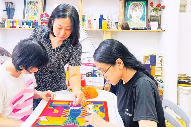 Xưởng thêu Len Art của Họa sĩ-nghệ nhân Nguyễn Thị Hồng Vân (giữa ảnh) giúp người khuyết tật tự tin hòa nhập cộng đồng.