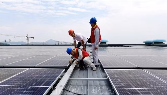 Các kỹ sư kiểm tra hệ thống điện mặt trời được lắp đặt trên mái ở tỉnh Chiết Giang, Trung Quốc. (Ảnh minh họa: China Daily/TTXVN)
