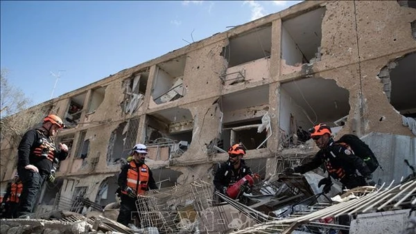 Lực lượng cứu hộ tại hiện trường vụ tấn công tên lửa của Iran xuống khu vực ở thành phố Dimona, Israel ngày 22/3/2026. (Ảnh: THX/TTXVN)