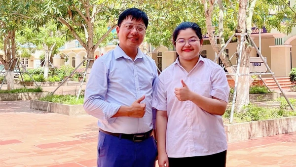 Thí sinh Nguyễn Thái An, học sinh trường THPT Kim Sơn A đạt điểm tuyệt đối 30/30 khối A00 và thầy giáo chủ nhiệm chụp ảnh lưu niệm. (Ảnh: Báo Ninh Bình)