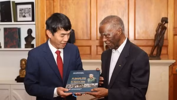 Đại sứ Hoàng Sỹ Cường trao tận tay cựu Tổng thống Nam Phi Thabo Mbeki cuốn sách “Võ Nguyên Giáp - vị tướng của nhân dân” song ngữ Việt-Anh, do con trai Đại tướng, ông Võ Hồng Nam, đề tặng. (Ảnh: TTXVN)