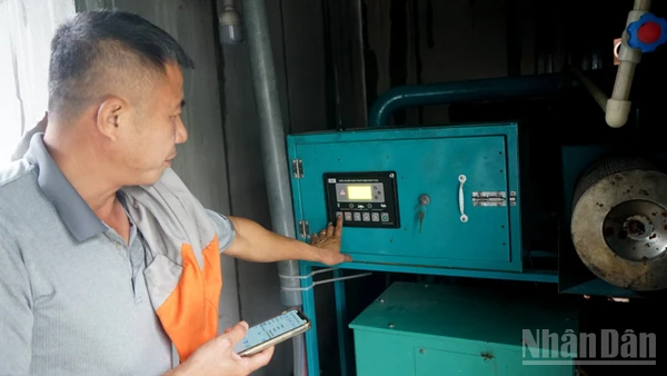 Ông Trần Xuân Phong vận hành máy phát điện từ khí biogas. (Ảnh: TRUNG HƯNG)