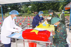 Cán bộ, chiến sĩ Đội lấy mẫu số 2 cẩn trọng thực hiện quy trình khai quật, thu thập mẫu sinh phẩm phục vụ công tác giám định ADN tại Nghĩa trang liệt sĩ tỉnh Gia Lai.