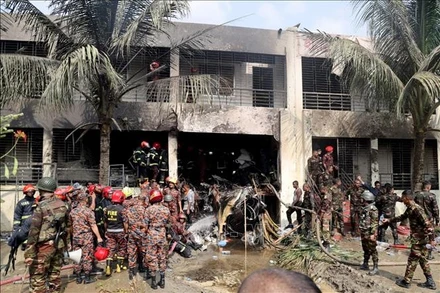 Binh sĩ và lính cứu hỏa Bangladesh làm nhiệm vụ tại hiện trường vụ rơi máy bay huấn luyện của Không quân nước này tại thủ đô Dhaka, ngày 21/7/2025. (Ảnh: TTXVN)