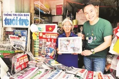 Nhà báo Trung Nghĩa tặng quà lưu niệm cho chủ sạp báo giấy lâu năm ở Thành phố Hồ Chí Minh. (Ảnh CTV)
