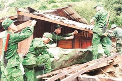 Bộ đội biên phòng giúp người dân xã Xa Dung tháo dỡ, di chuyển nhà cửa khỏi vùng nguy cơ thiên tai.