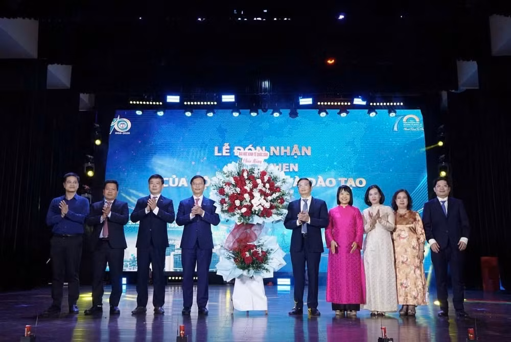 Lãnh đạo Đại học Kinh tế Quốc dân tặng hoa chúc mừng Viện Thương mại và Kinh tế quốc tế. (Ảnh: NEU)