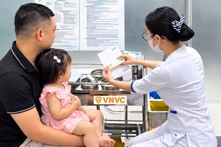 Nhân viên y tế tư vấn cho gia đình trước khi thực hiện tiêm vaccine tay chân miệng. (Ảnh: VNVC)