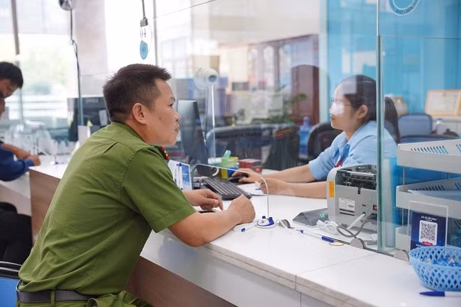 Thiếu tá Lò Văn Dũng làm thủ tục xác minh, chuyển hoàn số tiền cho người đã chuyển nhầm. Ảnh: ANH TUẤN