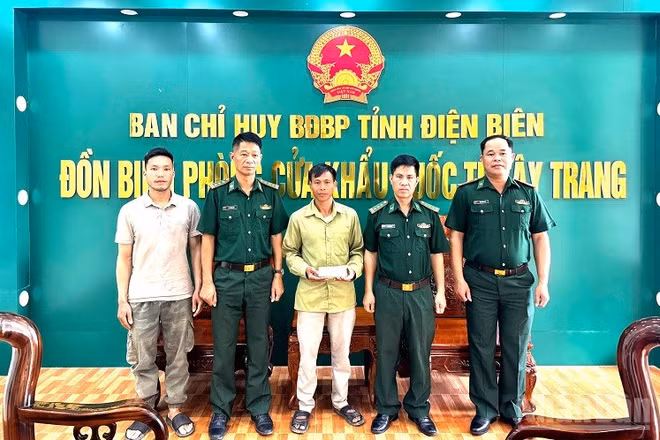 Đại diện lãnh đạo Đồn Biên phòng Cửa khẩu quốc tế Tây Trang chứng kiến Thiếu tá Nông Văn Thiết (người đầu tiên bên phải) trả lại tiền cho người đánh rơi. (Ảnh: LÊ LAN)