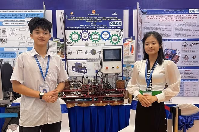 Em Nguyễn Tiến Mạnh và Dương Thị Duyên bên "Máy tách, tuốt vỏ cây tế - nguyên liệu sản xuất sản phẩm tiêu dùng xanh" được trao giải Tư tại Cuộc thi. 