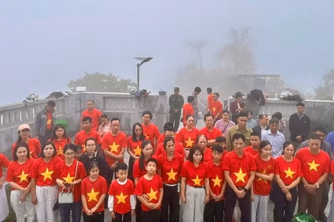 Du khách và nhân dân xã Sín Thầu thực hiện nghi lễ chào cờ dưới chân Cột cờ A Pa Chải trong Ngày Quốc tế Lao động 1/5.
