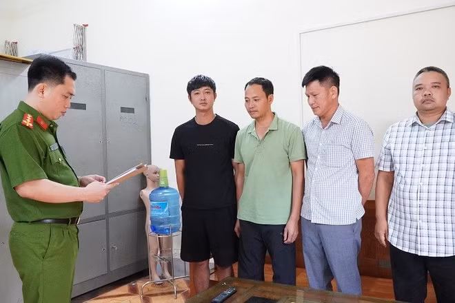 Cán bộ cơ quan điều tra Công an tỉnh Điện Biên đọc quyết định khởi tố bị can đối với 4 đối tượng. (Ảnh: CÔNG AN ĐIỆN BIÊN)