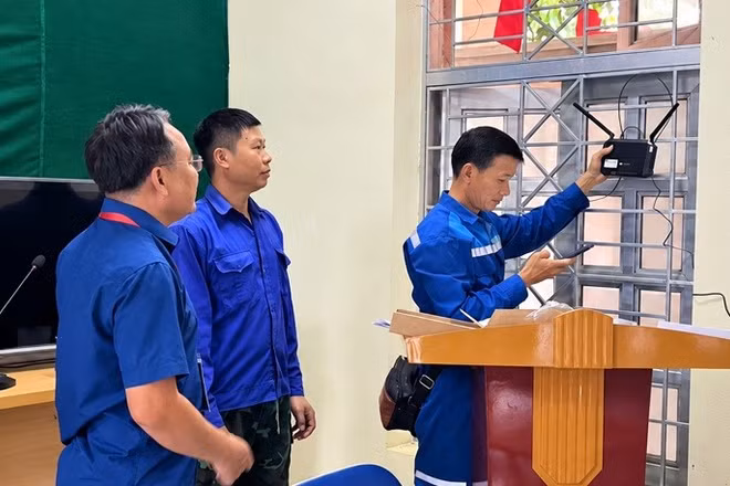 Công nhân đơn vị viễn thông lắp đặt bộ phát wi-fi tại Nhà Văn hóa bản Mường, xã Mường Mùn, tỉnh Điện Biên. (Ảnh: MƯỜNG MÙN)