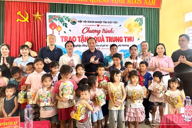 Ông Nguyễn Chí Ba, Phó Chủ tịch Hiệp hội Doanh nghiệp tỉnh Điện Biên cùng các doanh nghiệp thành viên Hiệp hội trao quà trung thu tặng các cháu học sinh bản Đề Chia, xã Pú Nhung. Ảnh: LÊ LAN