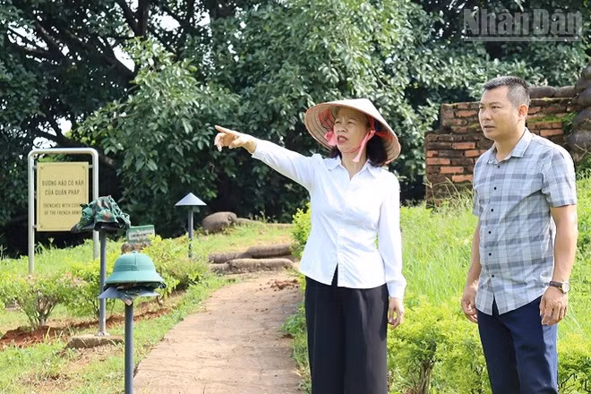 Giám đốc Bảo tàng Điện Biên Phủ Vũ Thị Tuyết Nga kiểm tra việc tu sửa, chỉnh trang cây xanh, vườn hoa tại các điểm di tích thuộc quần thể di tích chiến trường Điện Biên Phủ. (Ảnh: Lê Lan)