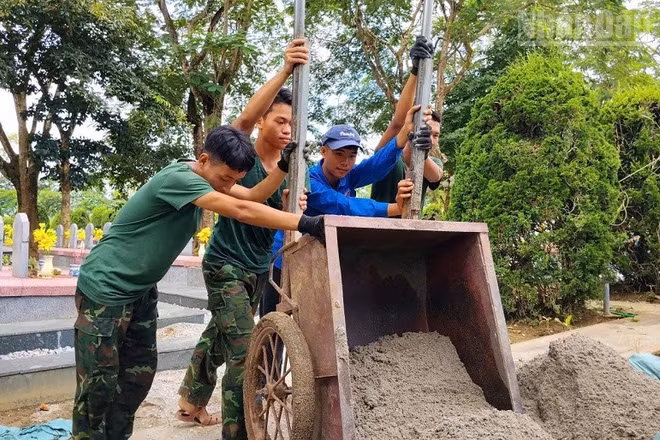 Đoàn viên, thanh niên Trường trung học phổ thông Thanh Nưa cùng các chiến sĩ thực hiện nhiệm vụ khai quật, lấy mẫu hài cốt liệt sĩ. (Ảnh: LÊ LAN)
