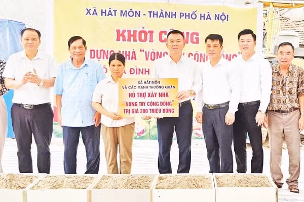 Bí thư Đảng ủy xã Hát Môn trao tiền hỗ trợ người dân xây dựng nhà ở.