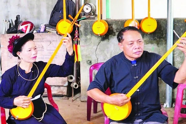 Đảng viên Nông Công Ngoạt và các thành viên trong câu lạc bộ thực hành đàn tính hát then trên những cây đàn do chính họ chế tác.