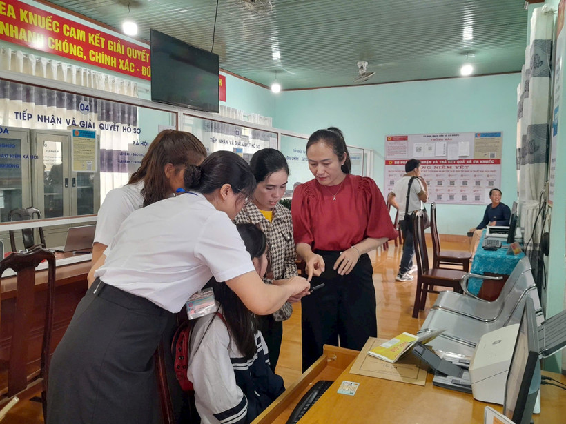 Đồng chí Ngô Thị Minh Trinh (bên phải)- Bí thư Đảng ủy xã Ea Knuếc, tỉnh Đắk Lắk, cùng cán bộ xã đang chỉ dẫn cho người dân làm thủ tục trên cổng dịch vụ công điện tử. (Ảnh LINH CẦM) 