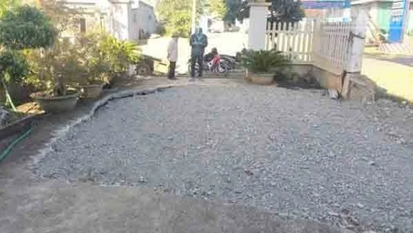 Khu vực sân của một hộ dân bị sụt lún đã được đổ đất đá trám lại.