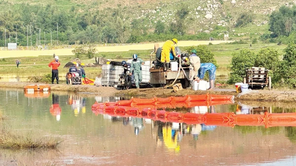 Lực lượng chức năng triển khai phao quây khoanh vùng ô nhiễm tại xã Vạn Tường, Khu kinh tế Dung Quất.