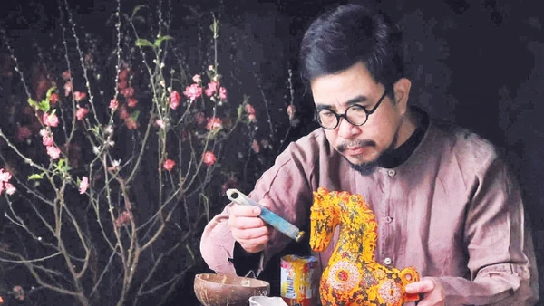 Nghệ nhân Nguyễn Tấn Phát trong quá trình sáng tạo tác phẩm sơn mài ngựa Bính Ngọ 2026. (Ảnh MINH NGUYỄN)