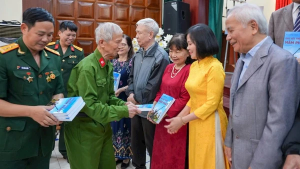 Thương binh, nhà giáo Nguyễn Thùy (hàng trên, thứ hai từ trái qua) trao tặng bạn đọc nhật ký thời chiến.