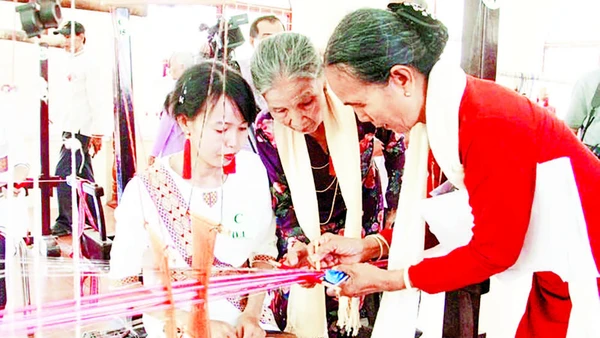 Nghệ nhân Đạt Thị Nam (áo cam) truyền dạy kỹ thuật dệt hoa văn Chăm cổ cho phụ nữ Chăm.