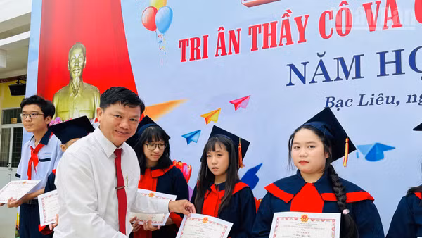 Thầy giáo Phan Thành Trung, Bí thư Chi bộ, Hiệu trưởng Trường Trung học cơ sở Lê Thị Cẩm Lệ, phường Bạc Liêu (Cà Mau), tặng giấy khen cho các em học sinh có thành tích học tập xuất sắc. (Ảnh: TRỌNG DUY)