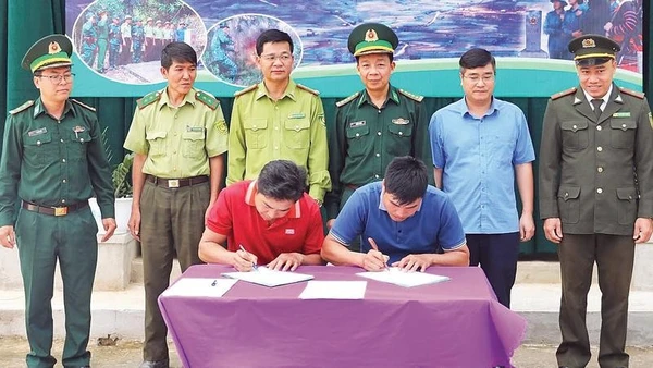 Đại diện nhân dân hai bản Pa Thơm (Điện Biên) và Na Luông (Lào) ký kết biên bản phối hợp phòng chống cháy rừng trong khu vực biên giới trước sự chứng kiến của chính quyền hai bên và Bộ đội Biên phòng tỉnh Điện Biên.