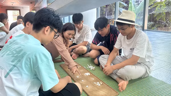 Các em nhỏ trải nghiệm trò chơi ô ăn quan. (Ảnh: Bảo tàng cung cấp)