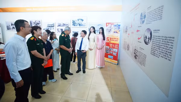 Nhà báo Phùng Công Sưởng, Tổng Biên tập Báo Tiền Phong giới thiệu với các đại biểu về triển lãm.