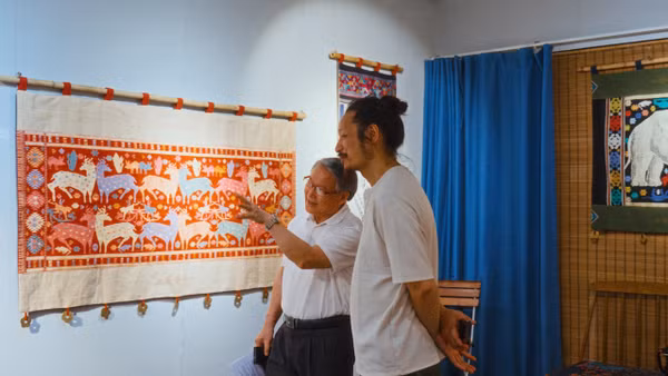 Họa sĩ Thái Tĩnh giới thiệu với người xem về một tác phẩm của mình. (Ảnh: NQ)