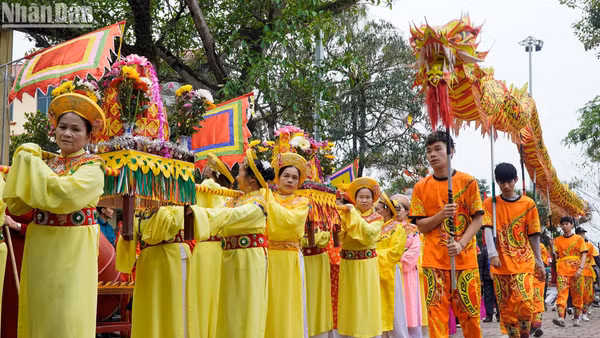 Người dân Bình Đà rước lễ vật ra Đình Nội. (Ảnh: HỮU TOÀN)