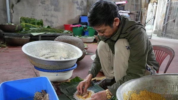 Ông Nguyễn Tất Lớ, làng Thủy Đường, gói bánh. (Ảnh: TTXVN)