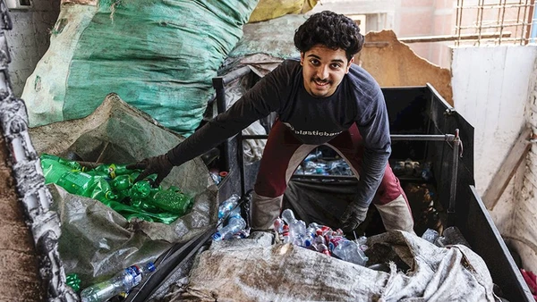 Mina đang phân loại chai lọ nhựa. Ảnh: THE GUARDIAN