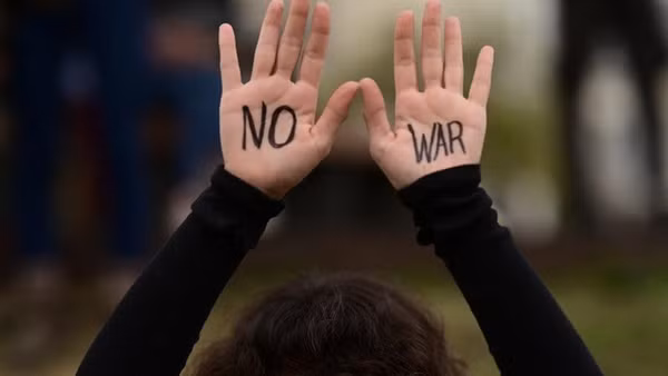 Một người biểu tình giơ cao hai tay được vẽ khẩu hiệu "Không chiến tranh" trong một cuộc biểu tình phản đối các cuộc tấn công của Mỹ và Israel vào Iran và yêu cầu chấm dứt mọi hành động chiến tranh tại Tel Aviv, Israel, ngày 14/3/2026. (Ảnh: Xinhua)