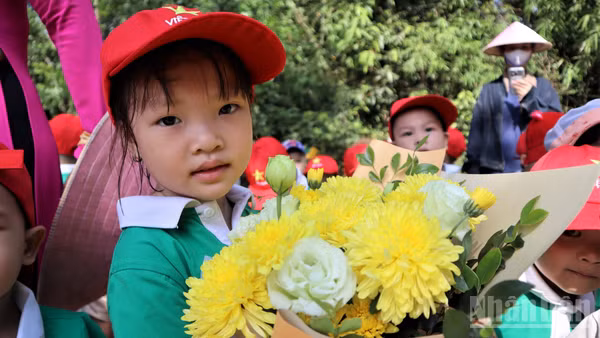 Các em nhỏ với những bó hoa tươi thắm dâng lên Bác Hồ kính yêu.