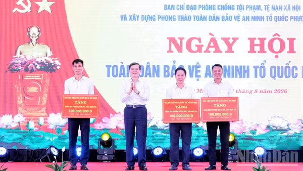 Đồng chí Đoàn Minh Huấn, Ủy viên Bộ Chính trị, Giám đốc Học viện Chính trị quốc gia Hồ Chí Minh tặng quà cho nhân dân các phường: Hoàng Mai, Tân Mai, Quỳnh Mai (Nghệ An). (Ảnh: PT)