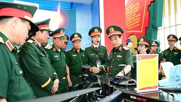 Đại tướng Phan Văn Giang kiểm tra khu trưng bày trong nhà của Bộ Quốc phòng tại Triển lãm thành tựu đất nước. (Ảnh VIỆT TRUNG)