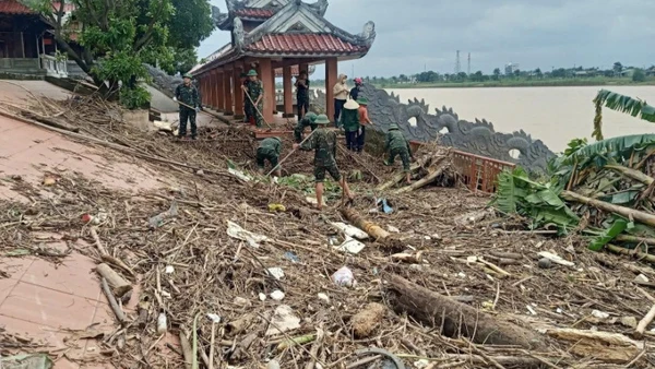 Cán bộ, chiến sĩ Ban Chỉ huy Phòng thủ Khu vực 4-Triệu Phong dọn dẹp rác và bùn tại Bến thả hoa bờ nam sông Thạch Hãn.