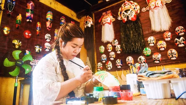 Huyền Trang vẽ mặt nạ tại không gian trưng bày và trải nghiệm của gia đình.